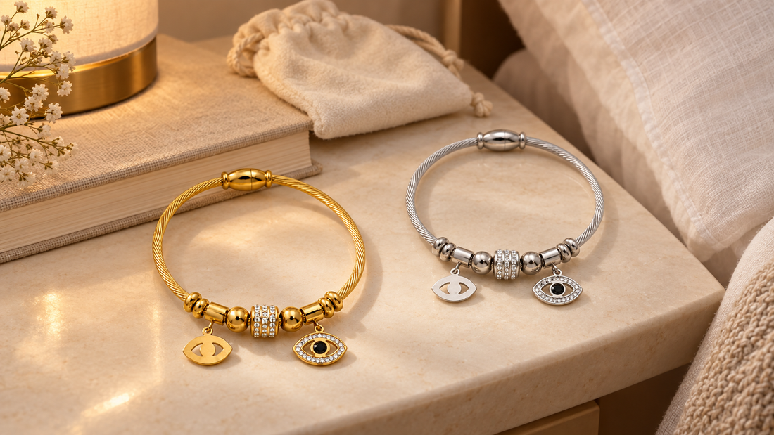 The Ilyra Ward gold-tone and The Argent Veil silver-tone evil eye bracelets on a bedside table