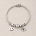 The Argent Veil silver evil eye bangle for protection energy and grounded boundaries, gift-ready styling image