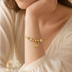 The Amorette Glow gold heart charm bangle for self-love and tender connection, close-up detail image