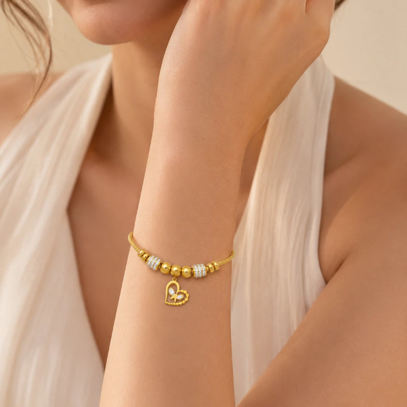 The Amorette Glow gold heart charm bangle for self-love and tender connection, gift-ready styling image