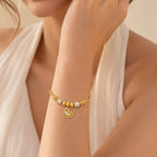 The Amorette Glow gold heart charm bangle for self-love and tender connection, gift-ready styling image