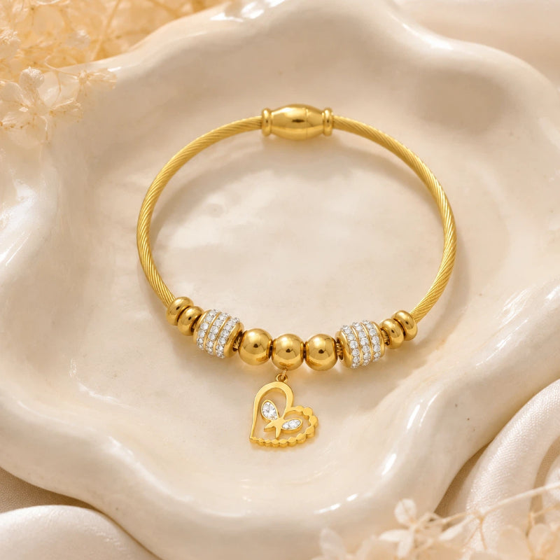 The Amorette Glow gold heart charm bangle for self-love and tender connection, lifestyle styling image